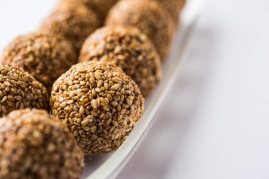 Tilgul Laddu veya Til Gul topu için makar sankranti, susam, ezilmiş fıstık ve jaggery kullanılarak yapılan bir sağlıklı besindir. bir kasede servis. seçici odak gösteren Ayrıntılar.