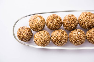 Tilgul Laddu veya Til Gul topu için makar sankranti, susam, ezilmiş fıstık ve jaggery kullanılarak yapılan bir sağlıklı besindir. bir kasede servis. seçici odak gösteren Ayrıntılar.