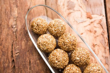 Tilgul Laddu veya Til Gul topu için makar sankranti, susam, ezilmiş fıstık ve jaggery kullanılarak yapılan bir sağlıklı besindir. bir kasede servis. seçici odak gösteren Ayrıntılar.