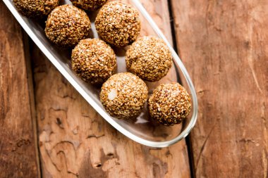 Tilgul Laddu veya Til Gul topu için makar sankranti, susam, ezilmiş fıstık ve jaggery kullanılarak yapılan bir sağlıklı besindir. bir kasede servis. seçici odak gösteren Ayrıntılar.