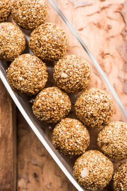 Tilgul Laddu veya Til Gul topu için makar sankranti, susam, ezilmiş fıstık ve jaggery kullanılarak yapılan bir sağlıklı besindir. bir kasede servis. seçici odak gösteren Ayrıntılar.