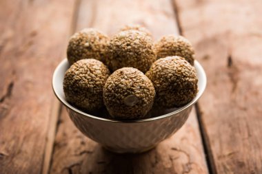 Tilgul Laddu veya Til Gul topu için makar sankranti, susam, ezilmiş fıstık ve jaggery kullanılarak yapılan bir sağlıklı besindir. bir kasede servis. seçici odak gösteren Ayrıntılar.