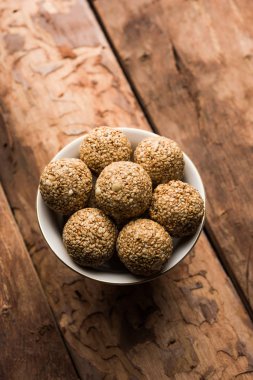 Tilgul Laddu veya Til Gul topu için makar sankranti, susam, ezilmiş fıstık ve jaggery kullanılarak yapılan bir sağlıklı besindir. bir kasede servis. seçici odak gösteren Ayrıntılar.