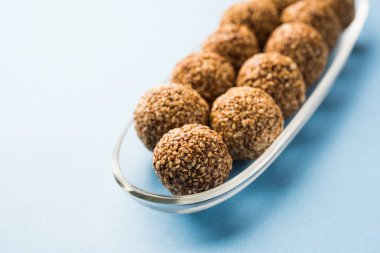 Tilgul Laddu veya Til Gul topu için makar sankranti, susam, ezilmiş fıstık ve jaggery kullanılarak yapılan bir sağlıklı besindir. bir kasede servis. seçici odak gösteren Ayrıntılar.