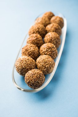 Tilgul Laddu veya Til Gul topu için makar sankranti, susam, ezilmiş fıstık ve jaggery kullanılarak yapılan bir sağlıklı besindir. bir kasede servis. seçici odak gösteren Ayrıntılar.