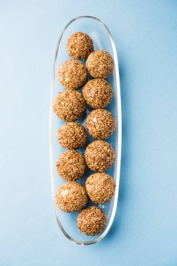 Tilgul Laddu veya Til Gul topu için makar sankranti, susam, ezilmiş fıstık ve jaggery kullanılarak yapılan bir sağlıklı besindir. bir kasede servis. seçici odak gösteren Ayrıntılar.
