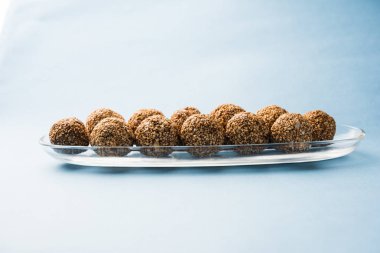 Tilgul Laddu veya Til Gul topu için makar sankranti, susam, ezilmiş fıstık ve jaggery kullanılarak yapılan bir sağlıklı besindir. bir kasede servis. seçici odak gösteren Ayrıntılar.