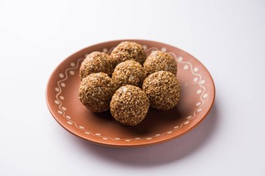 Tilgul Laddu veya Til Gul topu için makar sankranti, susam, ezilmiş fıstık ve jaggery kullanılarak yapılan bir sağlıklı besindir. bir kasede servis. seçici odak gösteren Ayrıntılar.