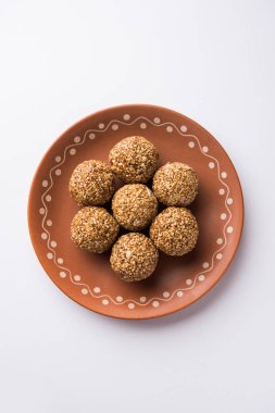Tilgul Laddu veya Til Gul topu için makar sankranti, susam, ezilmiş fıstık ve jaggery kullanılarak yapılan bir sağlıklı besindir. bir kasede servis. seçici odak gösteren Ayrıntılar.