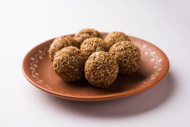Tilgul Laddu veya Til Gul topu için makar sankranti, susam, ezilmiş fıstık ve jaggery kullanılarak yapılan bir sağlıklı besindir. bir kasede servis. seçici odak gösteren Ayrıntılar.