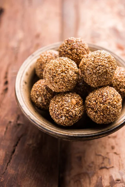 Tilgul Laddu or Til Gul balls for makar sankranti, it\'s a healthy food made using sesame, crushed peanuts and jaggery. served in a bowl. selective focus showing details.