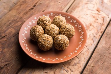 Tilgul Laddu veya Til Gul topu için makar sankranti, susam, ezilmiş fıstık ve jaggery kullanılarak yapılan bir sağlıklı besindir. bir kasede servis. seçici odak gösteren Ayrıntılar.