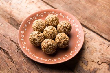 Tilgul Laddu veya Til Gul topu için makar sankranti, susam, ezilmiş fıstık ve jaggery kullanılarak yapılan bir sağlıklı besindir. bir kasede servis. seçici odak gösteren Ayrıntılar.