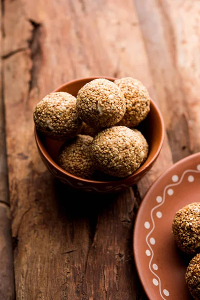 Tilgul Laddu or Til Gul balls for makar sankranti, it\'s a healthy food made using sesame, crushed peanuts and jaggery. served in a bowl. selective focus showing details.