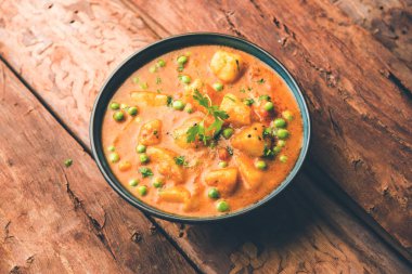 Hint Aloo Mutter köri - patates ve bezelye bir soğan domates et suyu dalmış ve kişniş yaprakları ile süslenmiş. Bir Karahi/kadhai veya pan veya kase servis. seçici odak