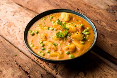 Hint Aloo Mutter köri - patates ve bezelye bir soğan domates et suyu dalmış ve kişniş yaprakları ile süslenmiş. Bir Karahi/kadhai veya pan veya kase servis. seçici odak