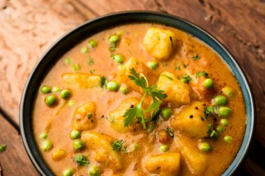 Hint Aloo Mutter köri - patates ve bezelye bir soğan domates et suyu dalmış ve kişniş yaprakları ile süslenmiş. Bir Karahi/kadhai veya pan veya kase servis. seçici odak