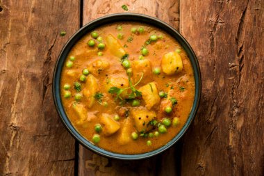 Hint Aloo Mutter köri - patates ve bezelye bir soğan domates et suyu dalmış ve kişniş yaprakları ile süslenmiş. Bir Karahi/kadhai veya pan veya kase servis. seçici odak