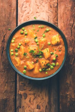 Hint Aloo Mutter köri - patates ve bezelye bir soğan domates et suyu dalmış ve kişniş yaprakları ile süslenmiş. Bir Karahi/kadhai veya pan veya kase servis. seçici odak