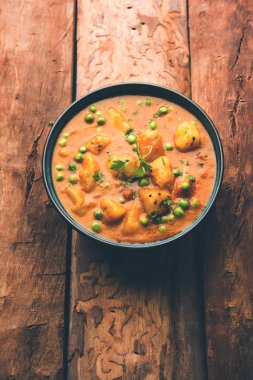 Hint Aloo Mutter köri - patates ve bezelye bir soğan domates et suyu dalmış ve kişniş yaprakları ile süslenmiş. Bir Karahi/kadhai veya pan veya kase servis. seçici odak