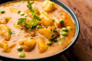 Hint Aloo Mutter köri - patates ve bezelye bir soğan domates et suyu dalmış ve kişniş yaprakları ile süslenmiş. Bir Karahi/kadhai veya pan veya kase servis. seçici odak