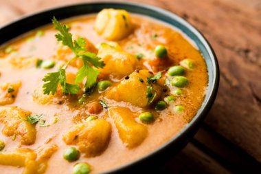 Hint Aloo Mutter köri - patates ve bezelye bir soğan domates et suyu dalmış ve kişniş yaprakları ile süslenmiş. Bir Karahi/kadhai veya pan veya kase servis. seçici odak