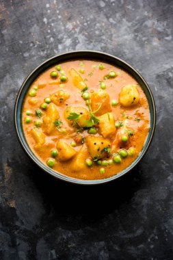 Hint Aloo Mutter köri - patates ve bezelye bir soğan domates et suyu dalmış ve kişniş yaprakları ile süslenmiş. Bir Karahi/kadhai veya pan veya kase servis. seçici odak