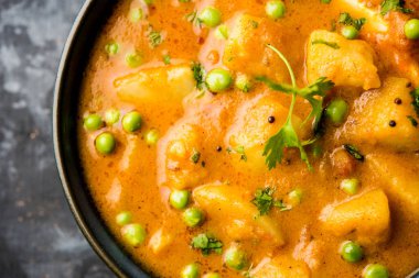 Hint Aloo Mutter köri - patates ve bezelye bir soğan domates et suyu dalmış ve kişniş yaprakları ile süslenmiş. Bir Karahi/kadhai veya pan veya kase servis. seçici odak