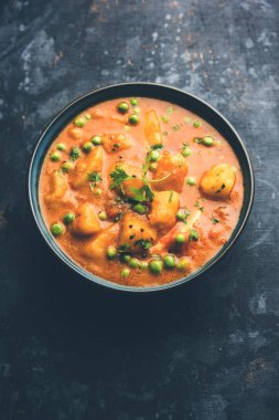 Hint Aloo Mutter köri - patates ve bezelye bir soğan domates et suyu dalmış ve kişniş yaprakları ile süslenmiş. Bir Karahi/kadhai veya pan veya kase servis. seçici odak