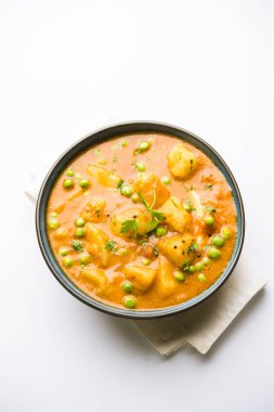 Hint Aloo Mutter köri - patates ve bezelye bir soğan domates et suyu dalmış ve kişniş yaprakları ile süslenmiş. Bir Karahi/kadhai veya pan veya kase servis. seçici odak