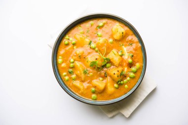 Hint Aloo Mutter köri - patates ve bezelye bir soğan domates et suyu dalmış ve kişniş yaprakları ile süslenmiş. Bir Karahi/kadhai veya pan veya kase servis. seçici odak