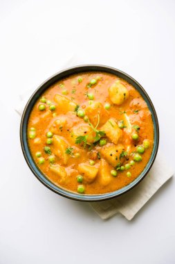 Hint Aloo Mutter köri - patates ve bezelye bir soğan domates et suyu dalmış ve kişniş yaprakları ile süslenmiş. Bir Karahi/kadhai veya pan veya kase servis. seçici odak