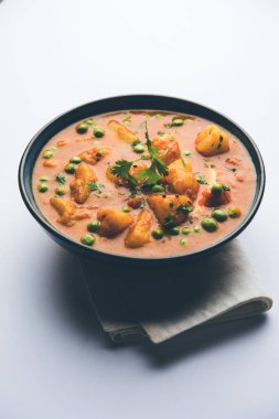 Hint Aloo Mutter köri - patates ve bezelye bir soğan domates et suyu dalmış ve kişniş yaprakları ile süslenmiş. Bir Karahi/kadhai veya pan veya kase servis. seçici odak