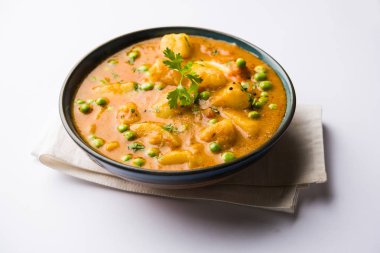 Hint Aloo Mutter köri - patates ve bezelye bir soğan domates et suyu dalmış ve kişniş yaprakları ile süslenmiş. Bir Karahi/kadhai veya pan veya kase servis. seçici odak