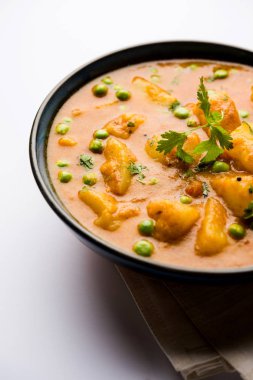 Hint Aloo Mutter köri - patates ve bezelye bir soğan domates et suyu dalmış ve kişniş yaprakları ile süslenmiş. Bir Karahi/kadhai veya pan veya kase servis. seçici odak