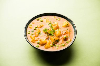 Hint Aloo Mutter köri - patates ve bezelye bir soğan domates et suyu dalmış ve kişniş yaprakları ile süslenmiş. Bir Karahi/kadhai veya pan veya kase servis. seçici odak