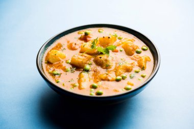 Hint Aloo Mutter köri - patates ve bezelye bir soğan domates et suyu dalmış ve kişniş yaprakları ile süslenmiş. Bir Karahi/kadhai veya pan veya kase servis. seçici odak