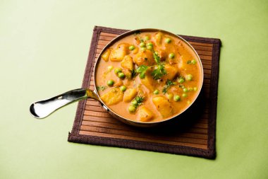 Hint Aloo Mutter köri - patates ve bezelye bir soğan domates et suyu dalmış ve kişniş yaprakları ile süslenmiş. Bir Karahi/kadhai veya pan veya kase servis. seçici odak