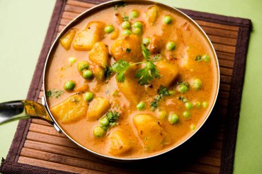 Hint Aloo Mutter köri - patates ve bezelye bir soğan domates et suyu dalmış ve kişniş yaprakları ile süslenmiş. Bir Karahi/kadhai veya pan veya kase servis. seçici odak