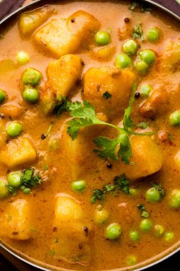 Hint Aloo Mutter köri - patates ve bezelye bir soğan domates et suyu dalmış ve kişniş yaprakları ile süslenmiş. Bir Karahi/kadhai veya pan veya kase servis. seçici odak