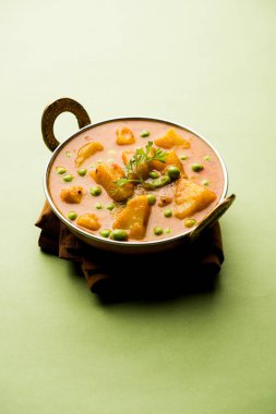 Hint Aloo Mutter köri - patates ve bezelye bir soğan domates et suyu dalmış ve kişniş yaprakları ile süslenmiş. Bir Karahi/kadhai veya pan veya kase servis. seçici odak