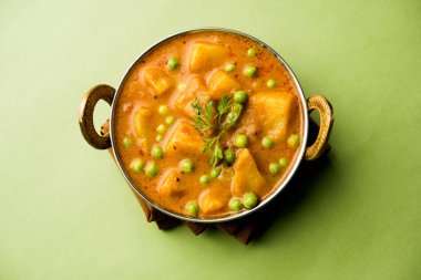 Hint Aloo Mutter köri - patates ve bezelye bir soğan domates et suyu dalmış ve kişniş yaprakları ile süslenmiş. Bir Karahi/kadhai veya pan veya kase servis. seçici odak