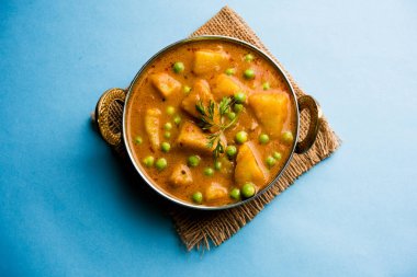 Hint Aloo Mutter köri - patates ve bezelye bir soğan domates et suyu dalmış ve kişniş yaprakları ile süslenmiş. Bir Karahi/kadhai veya pan veya kase servis. seçici odak