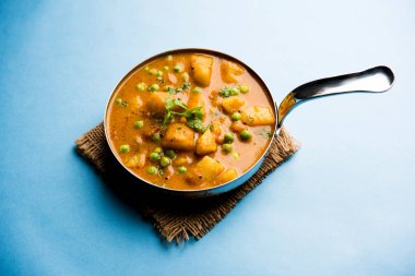 Hint Aloo Mutter köri - patates ve bezelye bir soğan domates et suyu dalmış ve kişniş yaprakları ile süslenmiş. Bir Karahi/kadhai veya pan veya kase servis. seçici odak