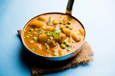 Hint Aloo Mutter köri - patates ve bezelye bir soğan domates et suyu dalmış ve kişniş yaprakları ile süslenmiş. Bir Karahi/kadhai veya pan veya kase servis. seçici odak