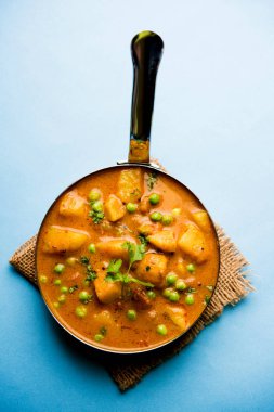 Hint Aloo Mutter köri - patates ve bezelye bir soğan domates et suyu dalmış ve kişniş yaprakları ile süslenmiş. Bir Karahi/kadhai veya pan veya kase servis. seçici odak
