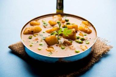 Hint Aloo Mutter köri - patates ve bezelye bir soğan domates et suyu dalmış ve kişniş yaprakları ile süslenmiş. Bir Karahi/kadhai veya pan veya kase servis. seçici odak