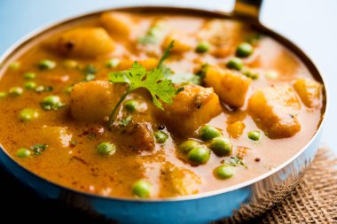 Hint Aloo Mutter köri - patates ve bezelye bir soğan domates et suyu dalmış ve kişniş yaprakları ile süslenmiş. Bir Karahi/kadhai veya pan veya kase servis. seçici odak