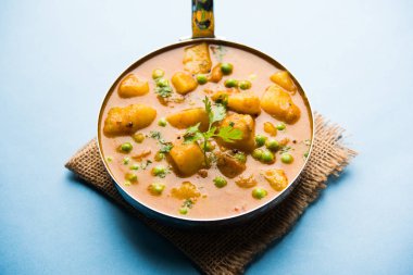 Hint Aloo Mutter köri - patates ve bezelye bir soğan domates et suyu dalmış ve kişniş yaprakları ile süslenmiş. Bir Karahi/kadhai veya pan veya kase servis. seçici odak