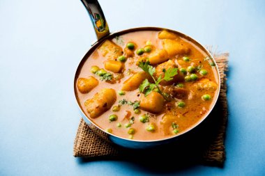 Hint Aloo Mutter köri - patates ve bezelye bir soğan domates et suyu dalmış ve kişniş yaprakları ile süslenmiş. Bir Karahi/kadhai veya pan veya kase servis. seçici odak